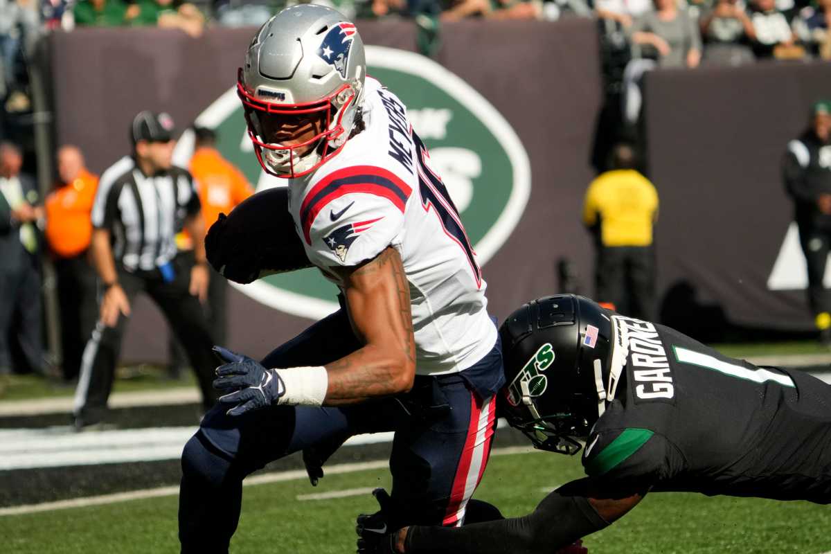 Patriots wide receiver Jakobi Meyers runs with the ball as Jets cornerback Sauce Gardner lunges to tackle him