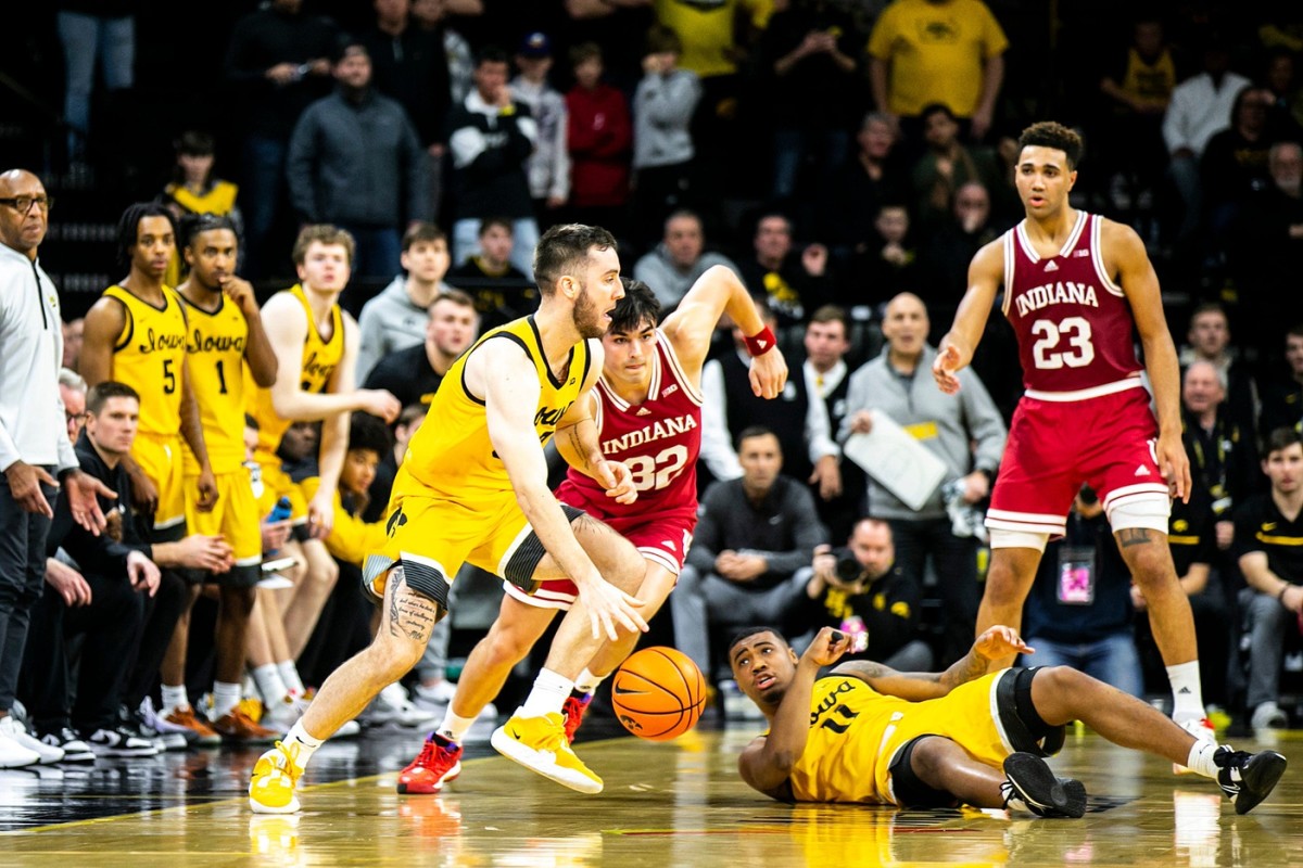 Indiana guard Trey Galloway, second from left, defends as Iowa guard Connor McCaffery, left, dribbles the ball as Iowa guard Tony Perkins (11) looks on during a NCAA Big Ten Conference men's basketball game.