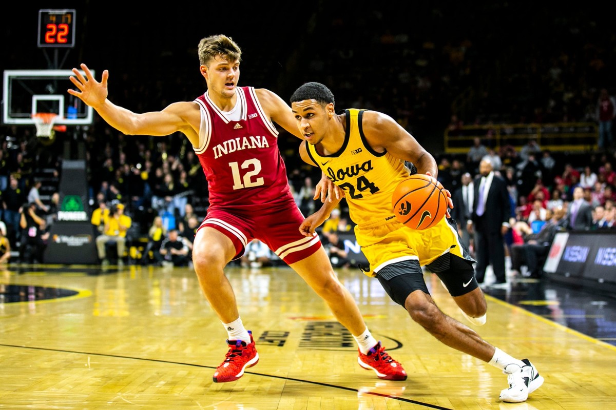 Iowa forward Kris Murray, right, drives to the basket as Indiana forward Miller Kopp defends during a NCAA Big Ten Conference men's basketball game.