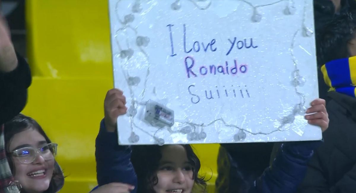 An Al Nassr fan pictured with a sign for Cristiano Ronaldo ahead of the club's game against Al Ta'ee in January 2023