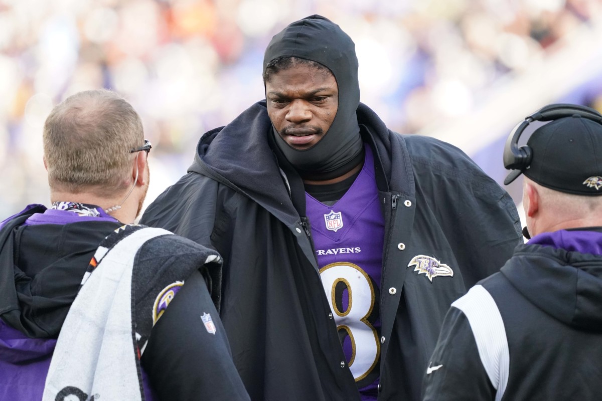 Lamar Jackson talks to coaches on the sideline during a game with the Baltimore Ravens.