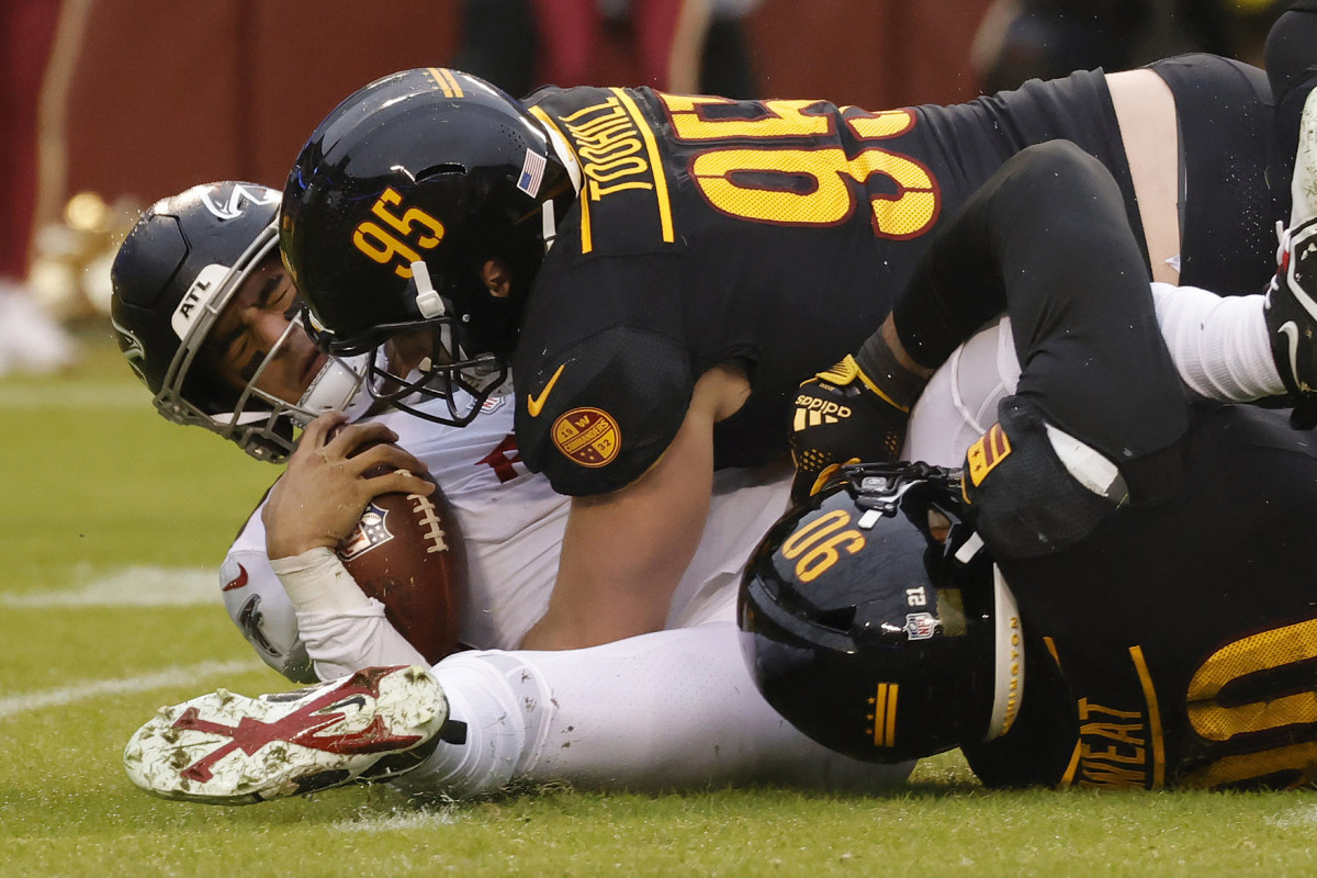 Washington Commanders defensive end Montez Sweat (90) and Commanders defensive end Casey Toohill (95) sack Atlanta Falcons quarterback Marcus Mariota (1) at FedExField.