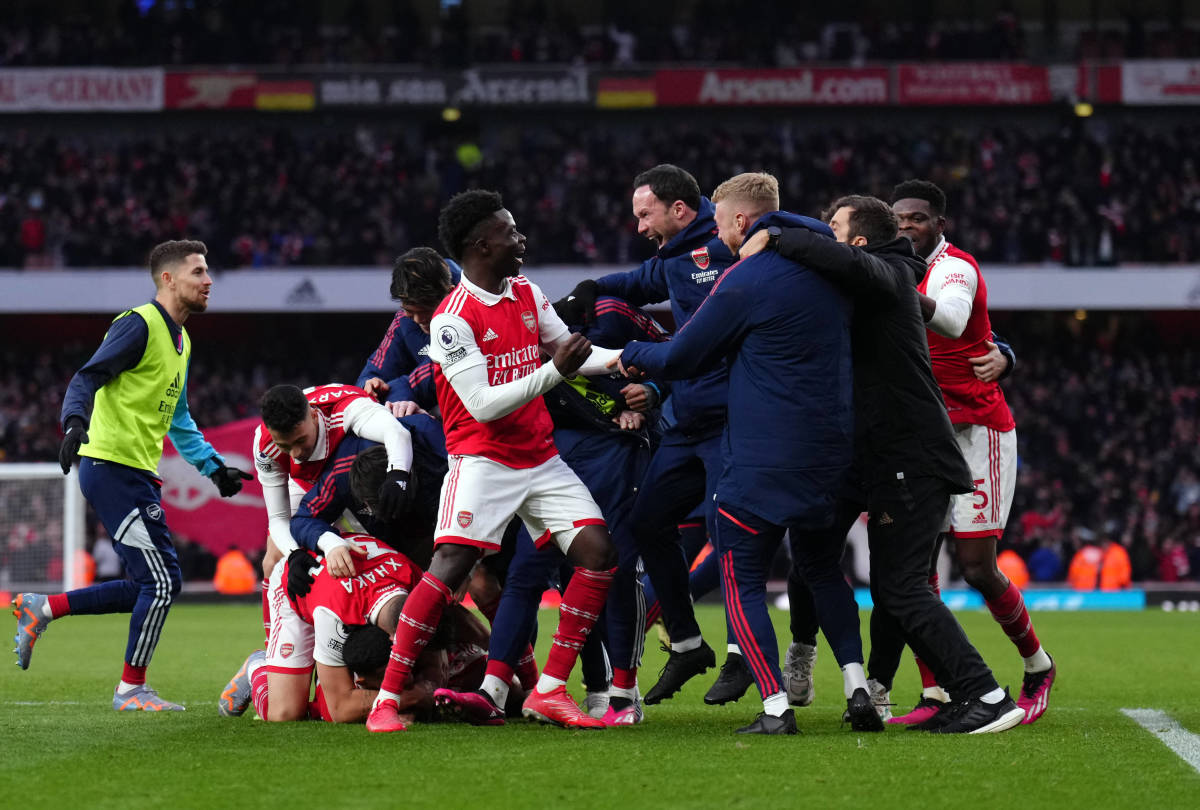 Players and coaches from Arsenal pictured celebrating on the pitch following Reiss Nelson's late goal against Bournemouth in March 2023