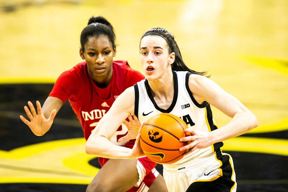 Iowa guard Caitlin Clark, right, passes the ball as Indiana guard Chloe Moore-McNeil defends during a NCAA Big Ten Conference women's basketball game, Sunday, Feb. 26, 2023, at Carver-Hawkeye Arena in Iowa City, Iowa.