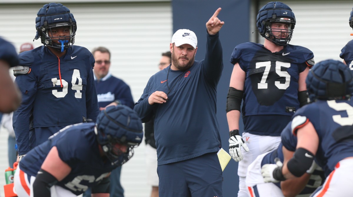 Terry Heffernan coaches the offensive linemen during a Virginia football practice outside the George Welsh Practice Facility.