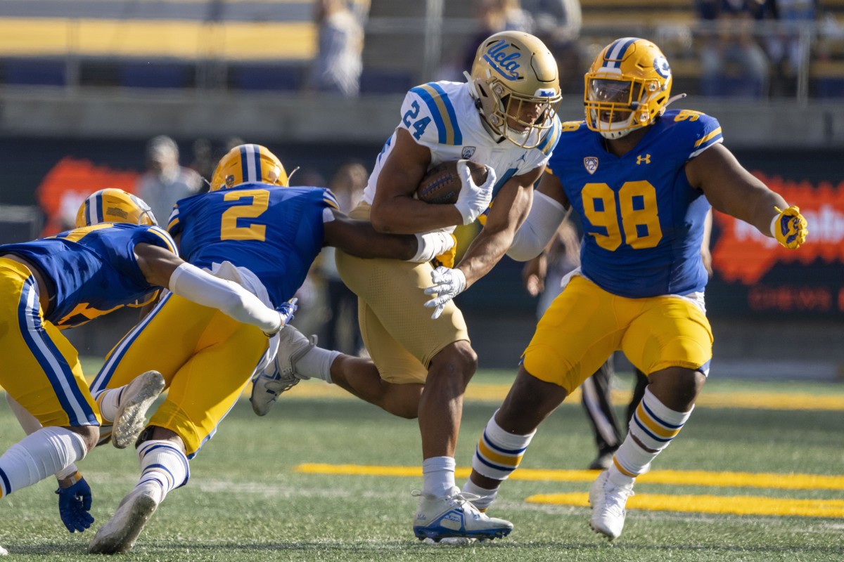 November 25, 2022; UCLA Bruins running back Zach Charbonnet (24) runs against California Golden Bears safety Craig Woodson (2) and defensive end Nate Burrell (98). Mandatory Credit: Kyle Terada-USA TODAY Sports