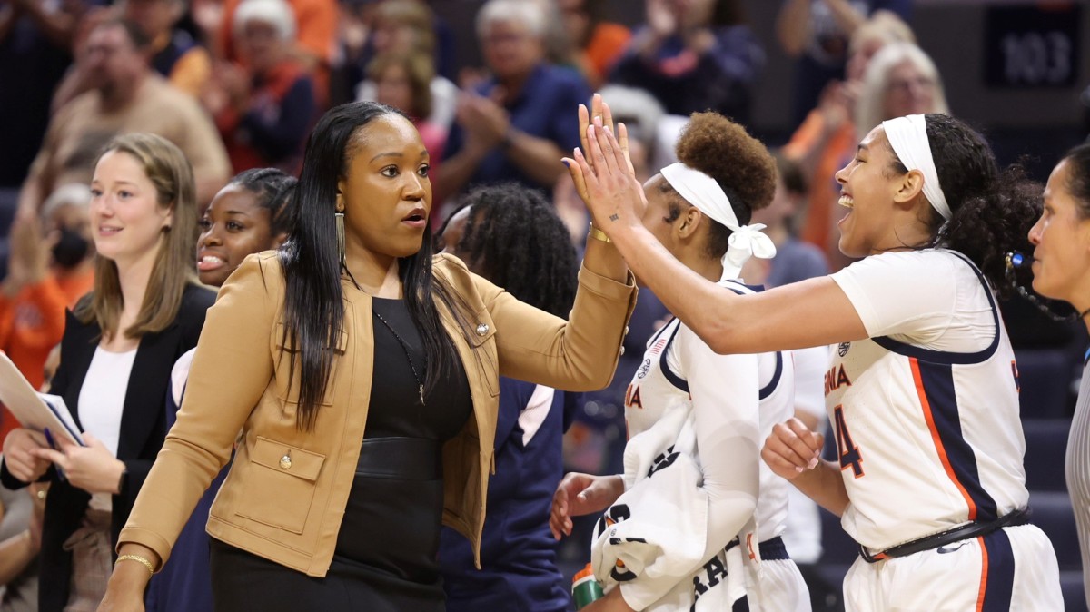 Amaka Agugua-Hamilton shakes hands with her team on the bench during the Virginia women's basketball game against George Washington at John Paul Jones Arena.