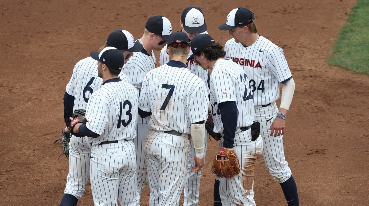 The Virginia baseball team huddles on third base during game 2 against Miami at Disharoon Park.