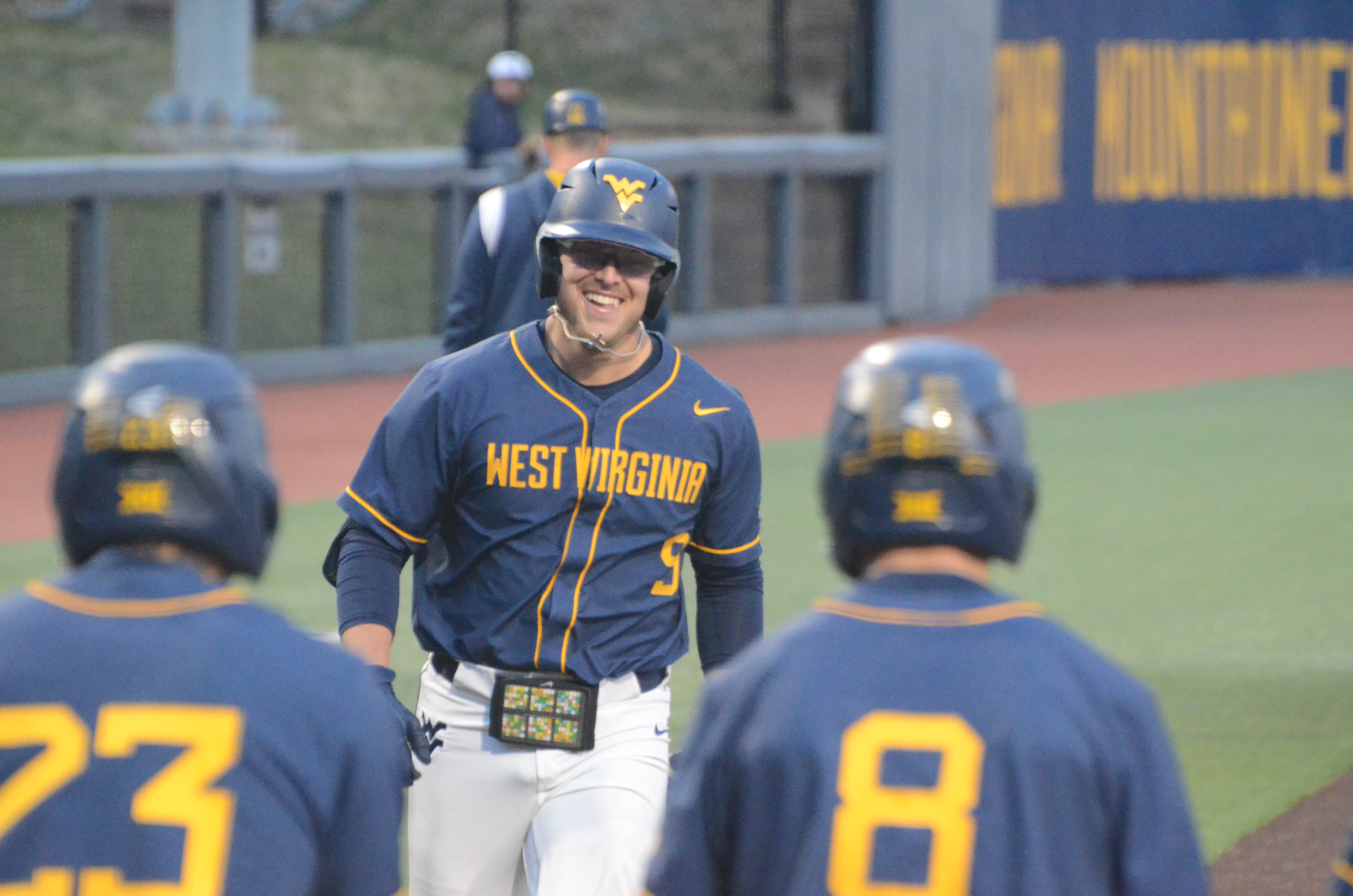 Apr 25, 2023; West Virginia sophomore Grant Hussey smiles at teammates Ellis Garcia (23) and Dayne Leonard (8) as he approaches home plate after smacking a grand slam in the bottom of the fourth inning versus Penn State.