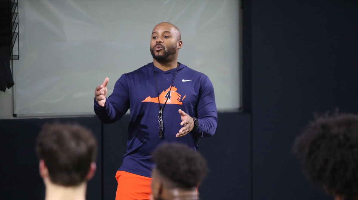 Virginia wide receivers coach Adam Mims speaks to his players during practice at the George Welsh Indoor Practice Facility.