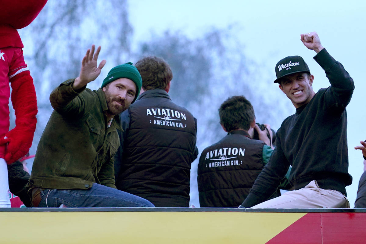 Wrexham co-owners, Ryan Reynolds (left) and Rob McElhenney (right) pictured during the club's open-top bus parade in May 2023 to celebrate both the men's and women's first-teams winning promotion