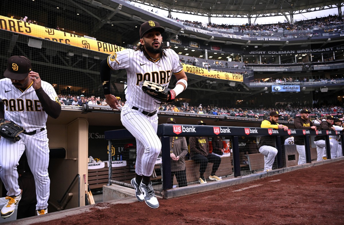 Fernando tatis jr in a padres jersey celebrating with a world