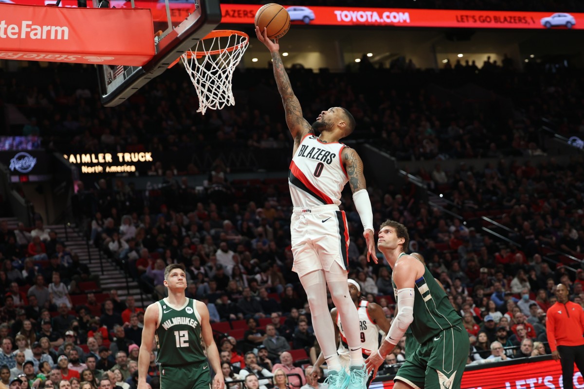 Portland Trail Blazers guard Damian Lillard (0) scores over Milwaukee Bucks center Brook Lopez (11)