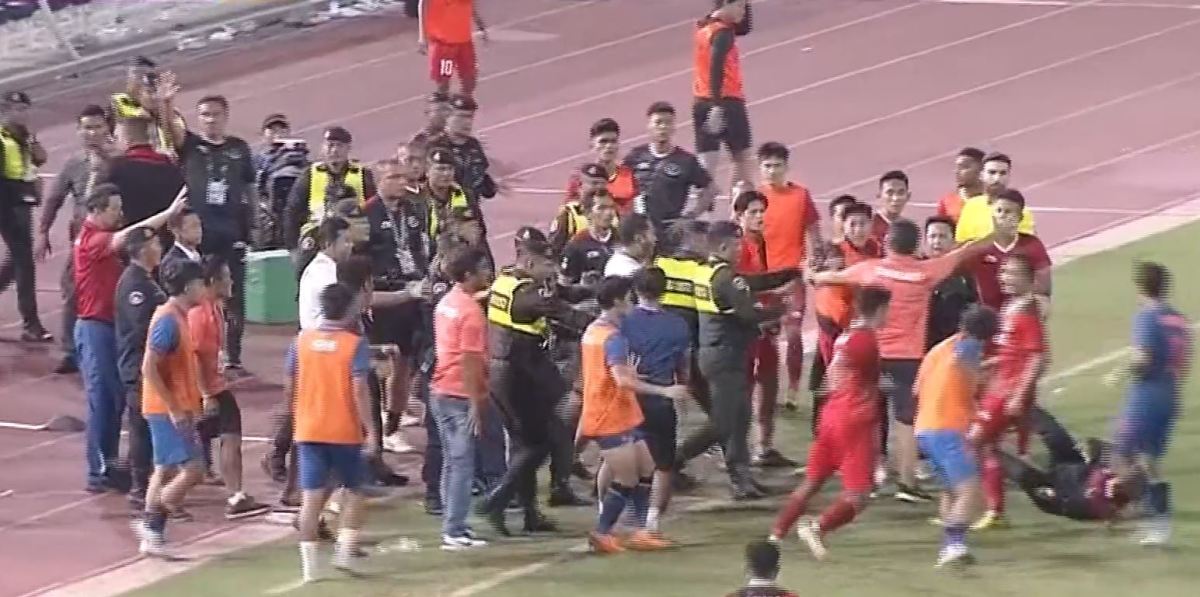 Police in Cambodia pictured attempting to break up fighting between players and staff during a game between Indonesia and Thailand in May 2023