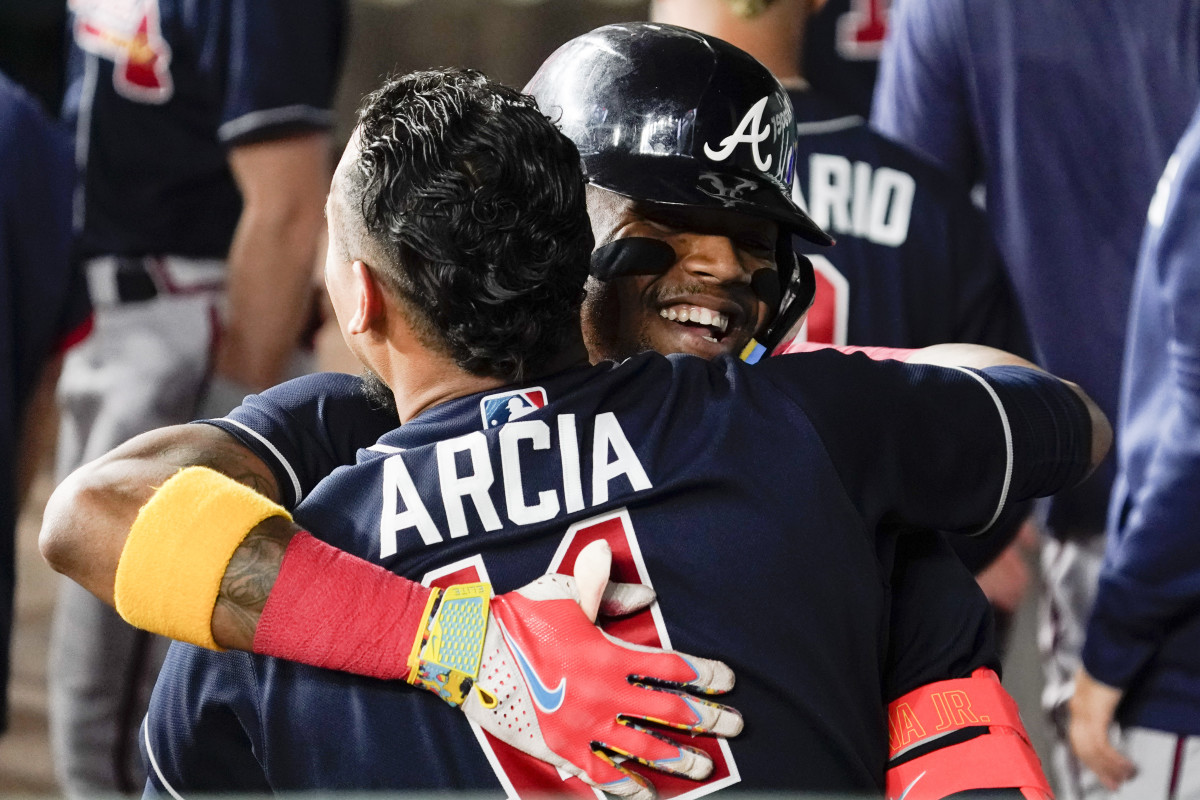 May 17, 2023; Arlington, Texas, USA; Atlanta Braves right fielder Ronald Acuna Jr. (13) hugs shortstop Orlando Arcia (11) in the dugout after hitting a solo home run against the Texas Rangers during the sixth inning at Globe Life Field. Mandatory Credit: Raymond Carlin III-USA TODAY Sports