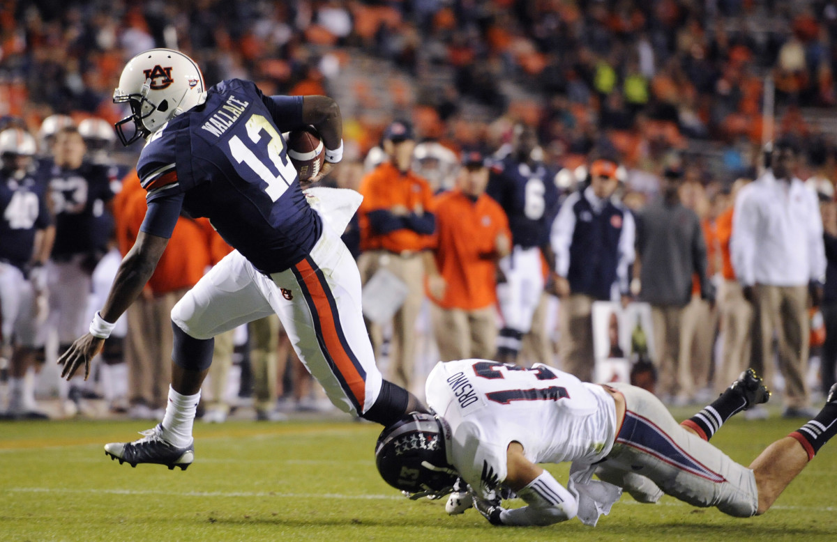 Oct 26, 2013; Auburn, AL, USA; Auburn Tigers quarterback Jonathan Wallace (12) escapes the defense of Florida Atlantic Owls safety Josh Orsino (13) at Jordan Hare Stadium. The Tigers beat the Owls 45-10. Mandatory Credit: Shanna Lockwood-USA TODAY Sports