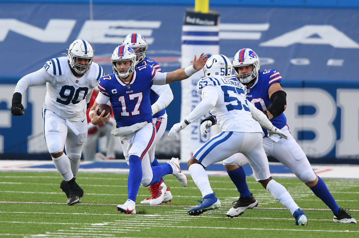Josh Allen runs with the ball as two Colts defenders reach to tackle him