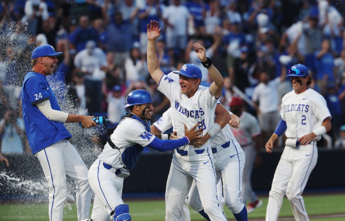 UK's Mason Moore (20) was rushed by catcher Devin Burkes (7) and other teammates as they doused him in shower after he delivered the last pitch to secure a 4-2 victory against Indiana during the NCAA Regional final in Lexington Ky. on June 5, 2023. The win earned UK a spot in the upcoming Super Regional in Louisiana.