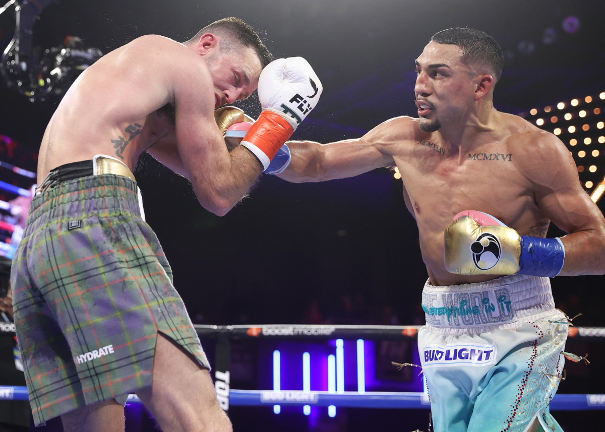 Teofimo Lopez lands a punch on Josh Taylor during their junior welterweight boxing title fight.