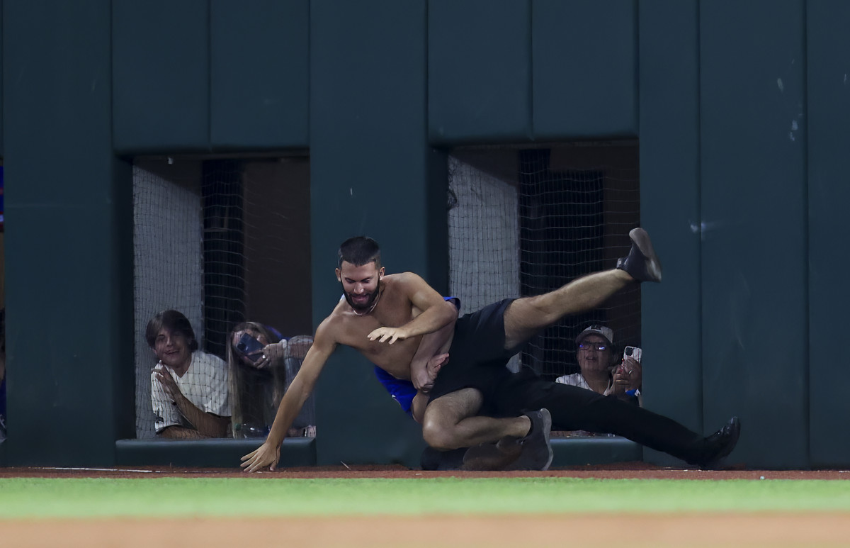 Jun 16, 2023; Arlington, Texas, USA; A fan is tackled by security during the game between the Texas Rangers and Toronto Blue Jays at Globe Life Field. Mandatory Credit: Kevin Jairaj-USA TODAY Sports