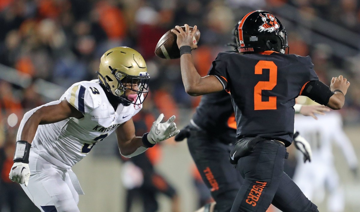 Hoban linebacker Rickey Williams, left, rushes to Massillon quarterback Jalen Slaughter during the first half of an OHSAA Division II state semifinal, Friday, Nov. 25, 2022, in Akron.