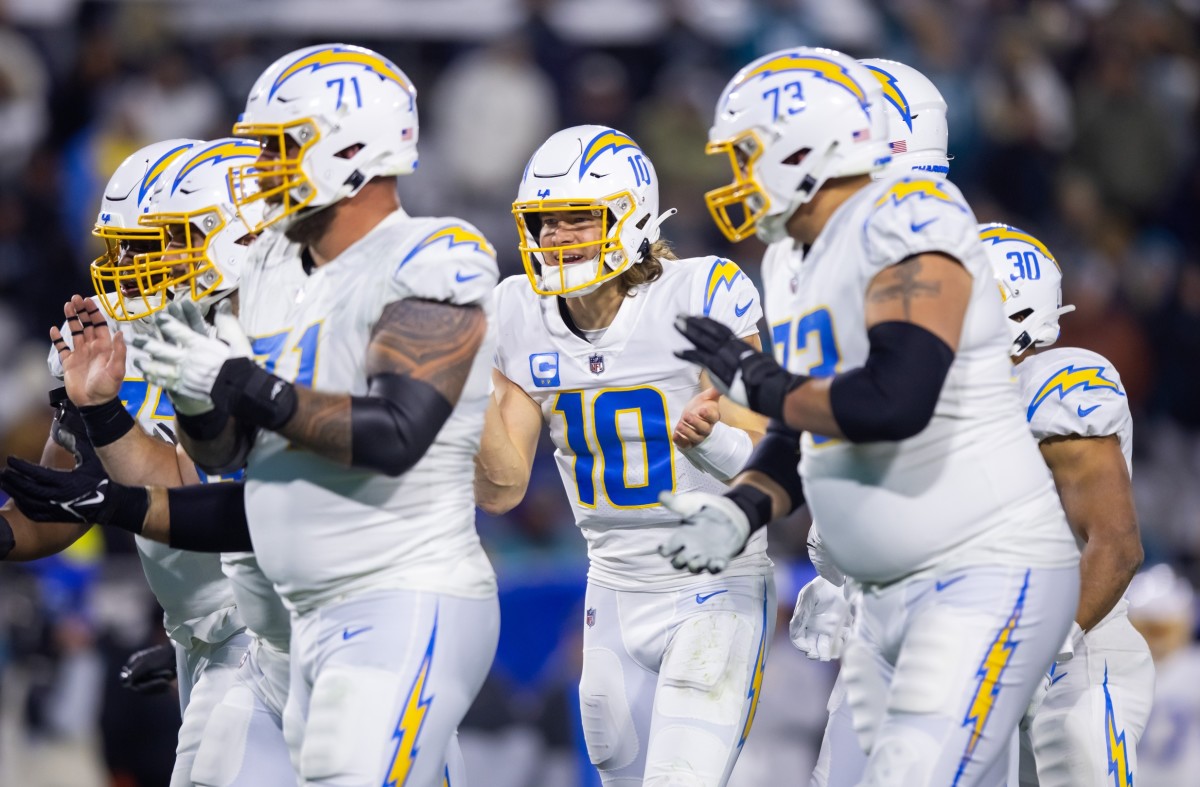 Los Angeles Chargers quarterback Justin Herbert (10) adjusts his helmet as  he warms up before an NFL football game against the Seattle Seahawks Sunday,  Oct. 23, 2022, in Inglewood, Calif. (AP Photo/Marcio