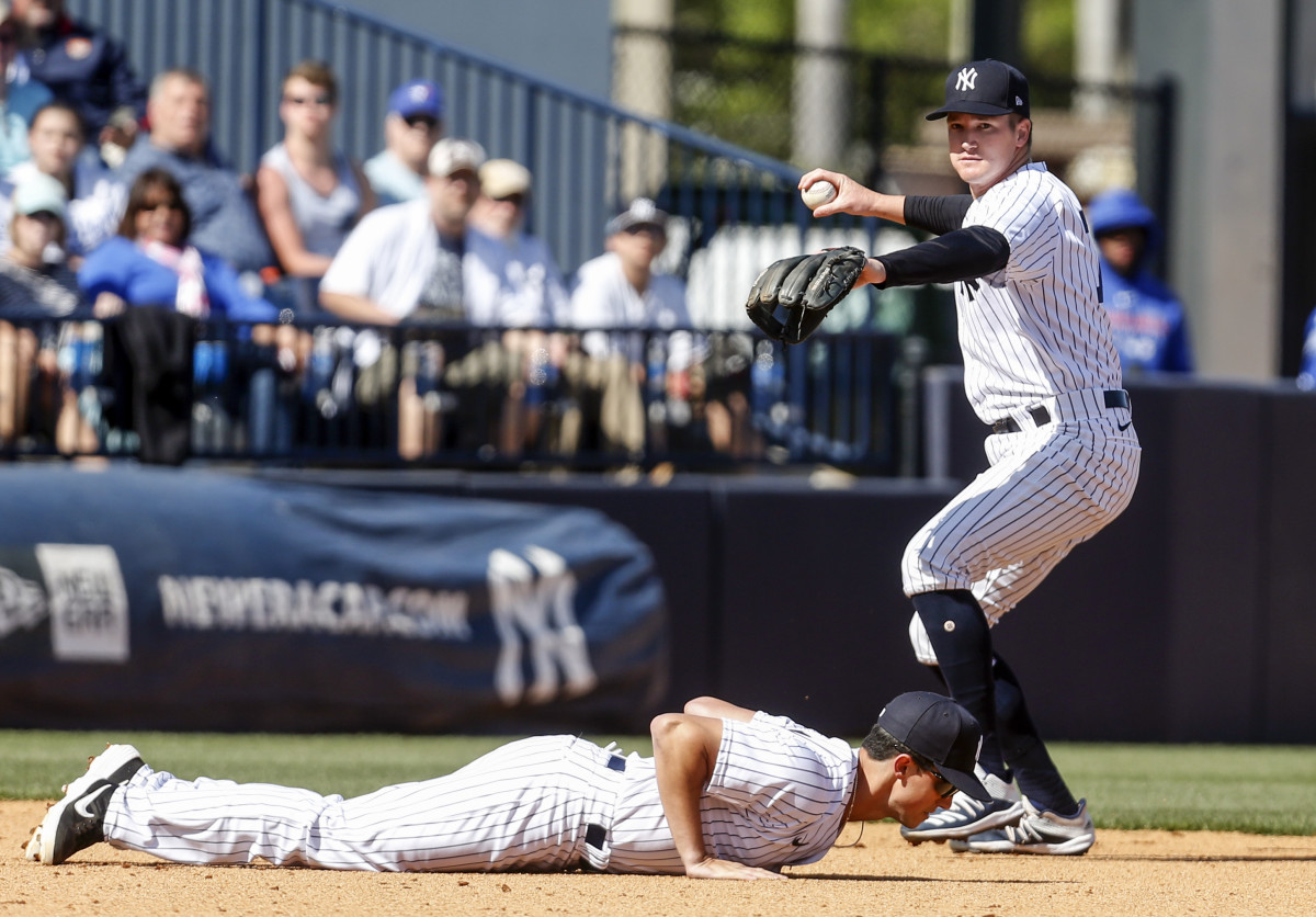 New York Yankees short stop Kyle Holder throws to first as third baseman Armando Alvarez ducks out of the way. (2020)