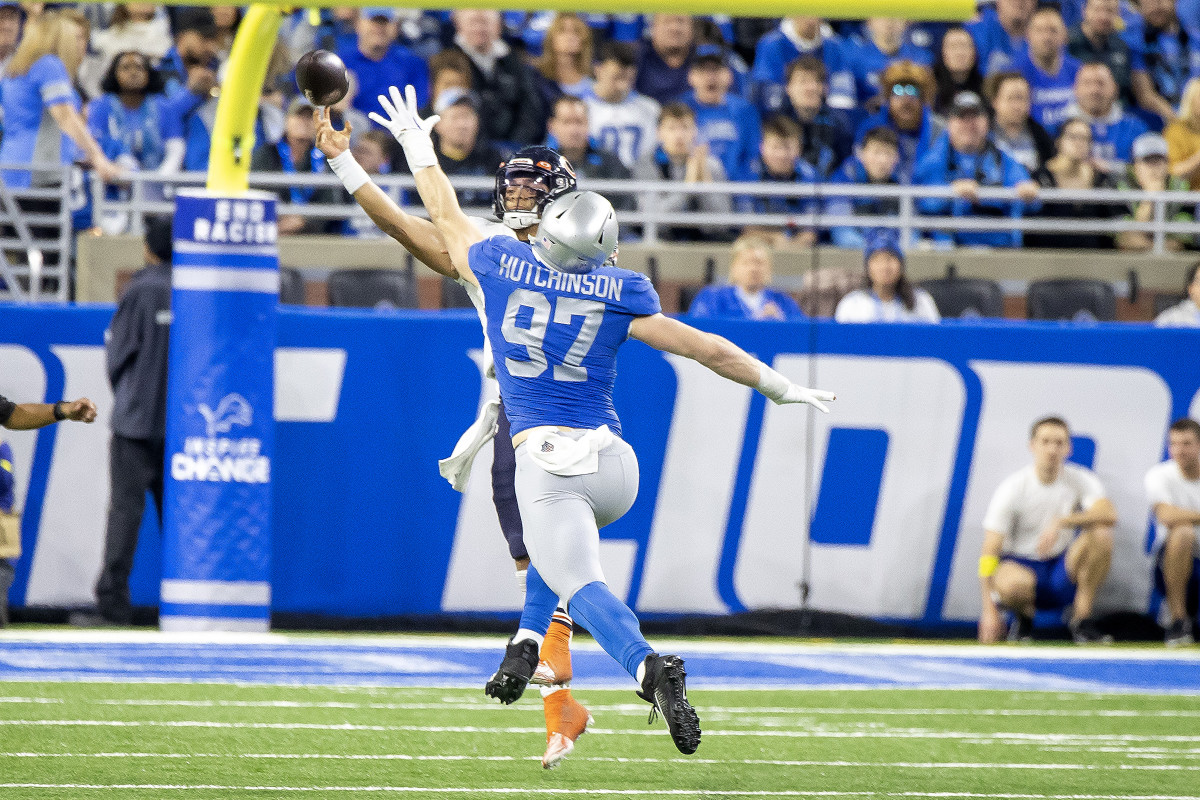 Detroit Lions defensive end Aidan Hutchinson reaches a hand up as he runs toward QB Justin Fields