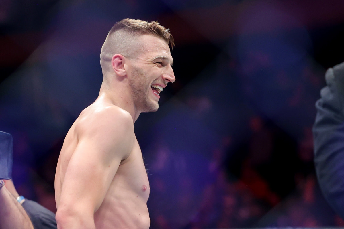 UFC fighter Dan Hooker smiles inside the Octagon after picking up a win.