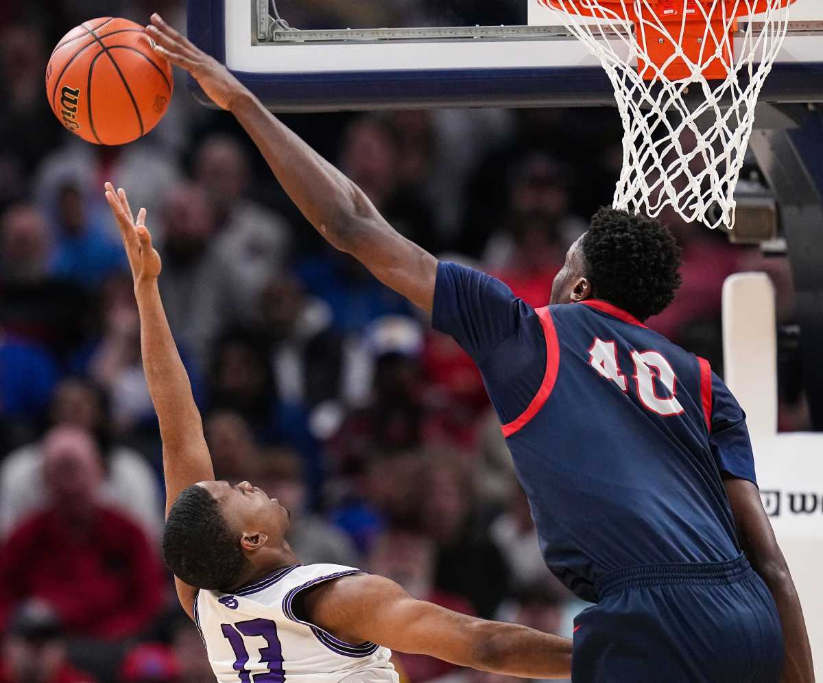 Flory Bidunga reaches his arm out to block a shot from another player below him