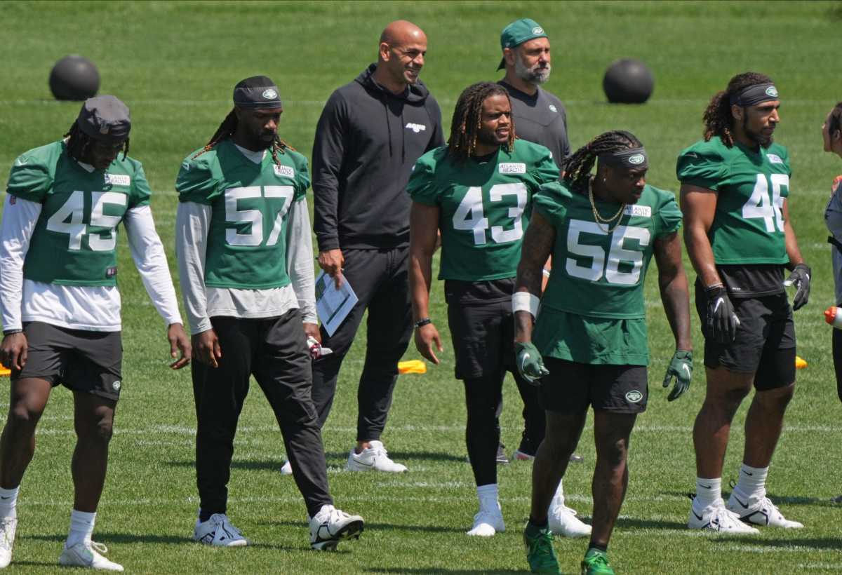 Robert Saleh walks behind a group of Jets players at OTAs