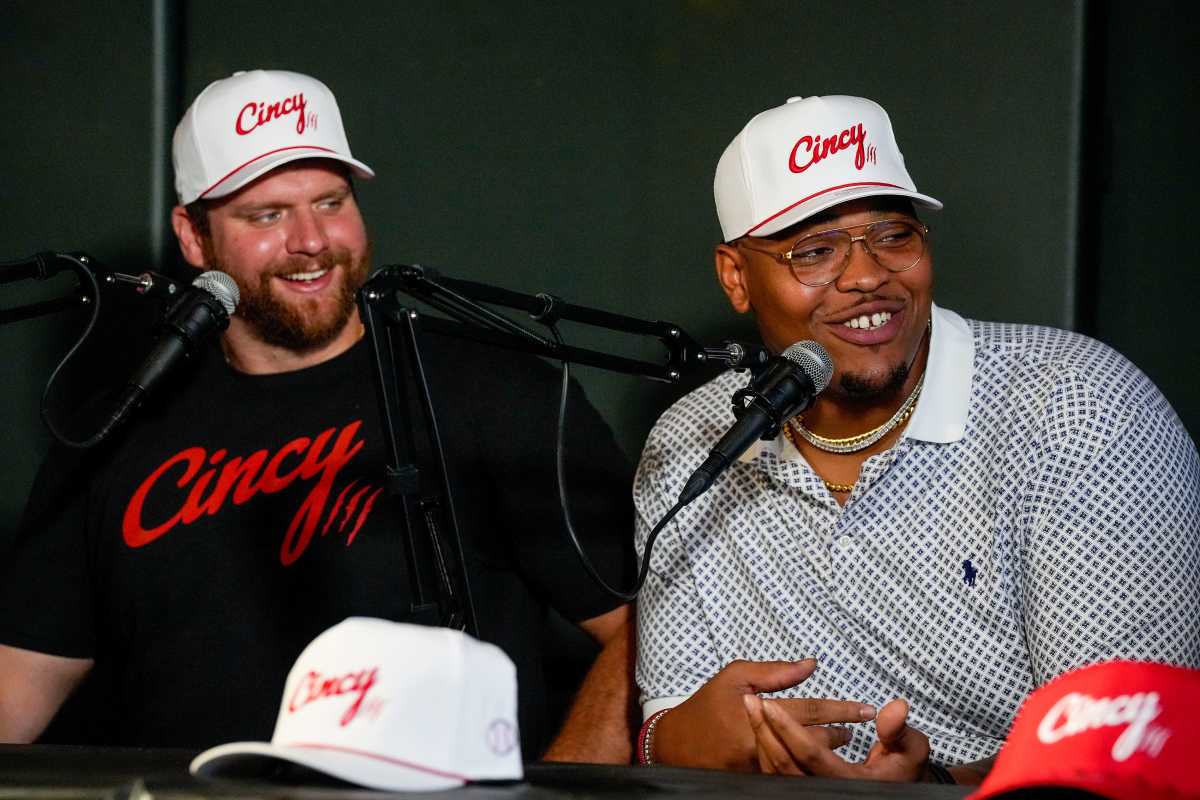 center Ted Karras and Bengals offensive tackle Orlando Brown Jr. sit side by side talking into two microphones