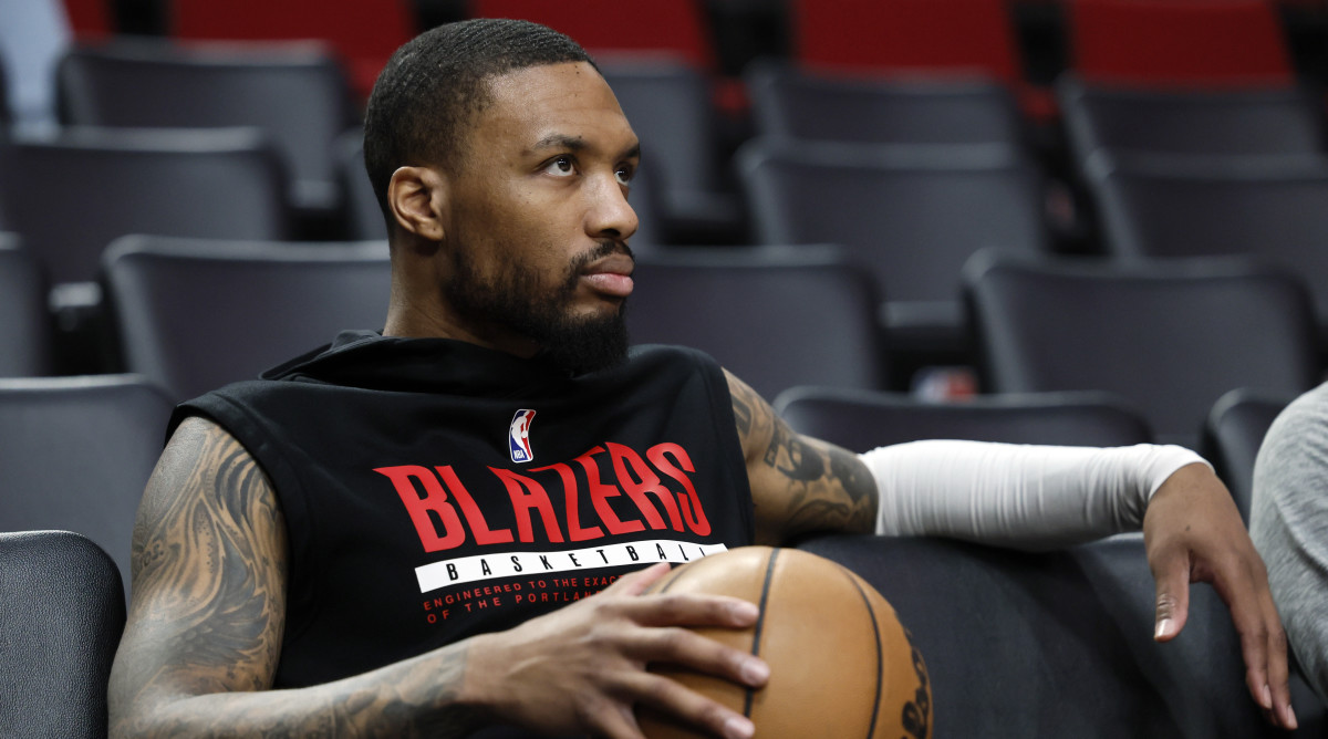 Trail Blazers point guard Damian Lillard sits in a courtside chair