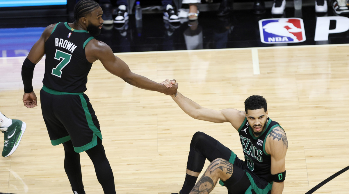 Celtics guard Jaylen Brown helps up forward Jayson Tatum.