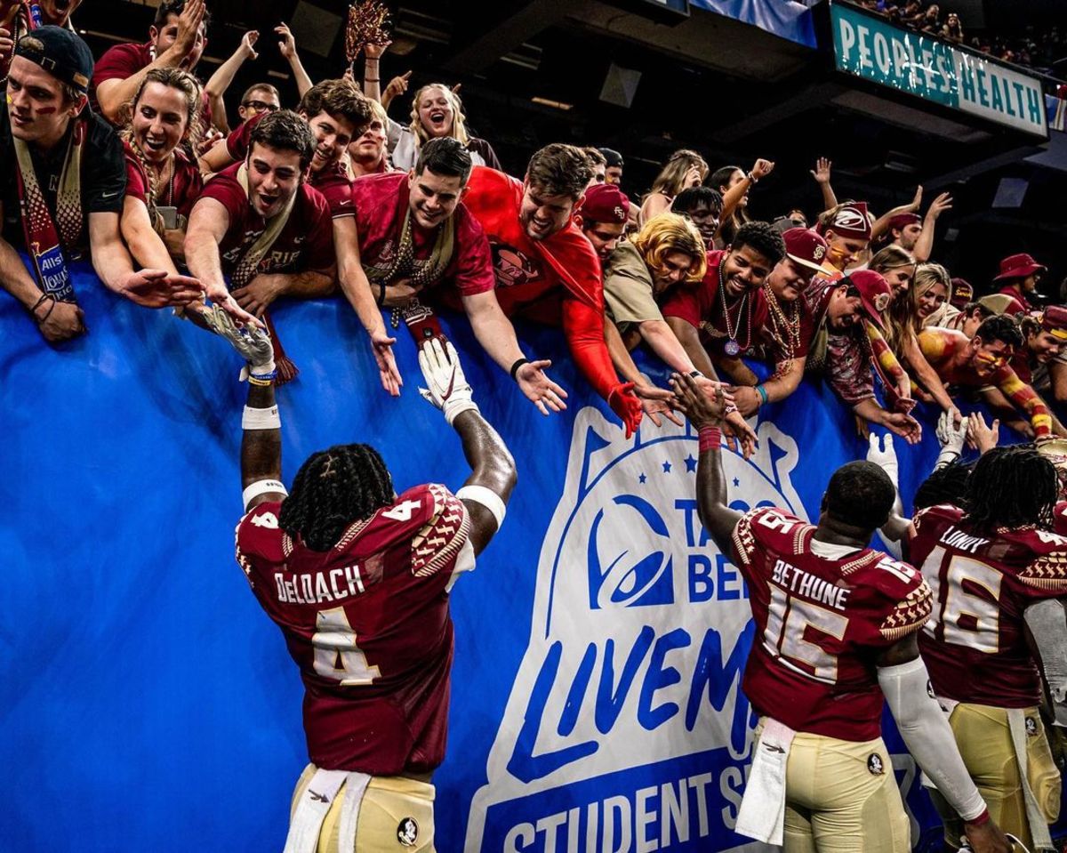 FSU linebackers Kalen DeLoach, Tatum Bethune and DJ Lundy celebrate with Florida State fans in the Taco Bell Live Mas Student section.