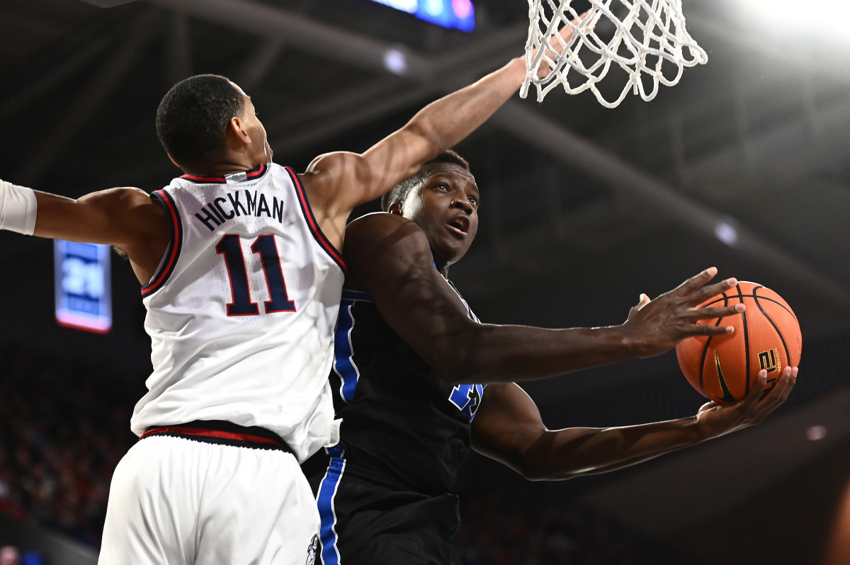 BYU forward Fousseyni Traore shoots the ball against Gonzaga Bulldogs guard Nolan Hickman.