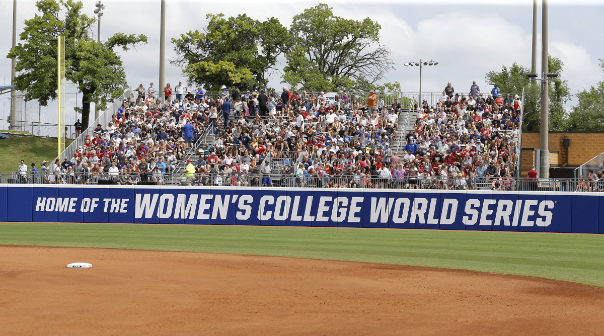 Fans watch the opening game from outfield seating of an NCAA softball Women’s College World Series game.