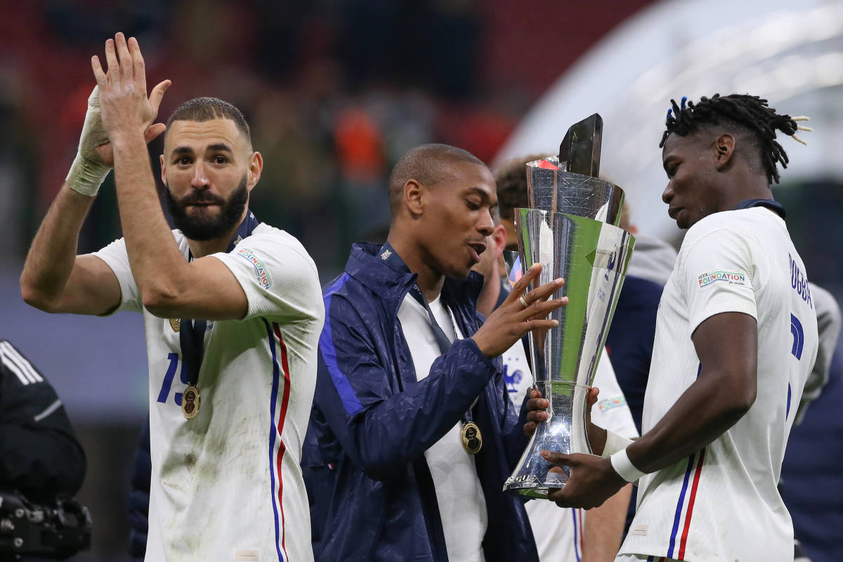 Karim Benzema applauds fans as France teammates Anthony Martial (center) and Paul Pogba (right) hold the UEFA Nations League trophy in October 2021