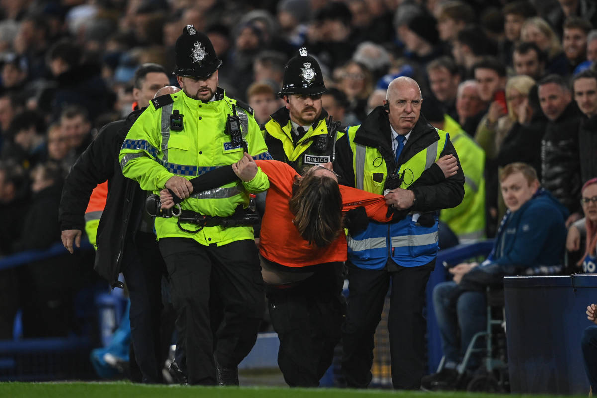 Police carry away a protester after he invaded the Goodison Park pitch during Everton vs Newcastle and tied his own neck to a goalpost