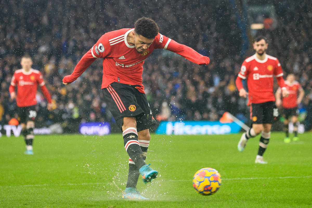 Jadon Sancho pictured striking a ball on a wet surface during Manchester United's win at Leeds in February 2022