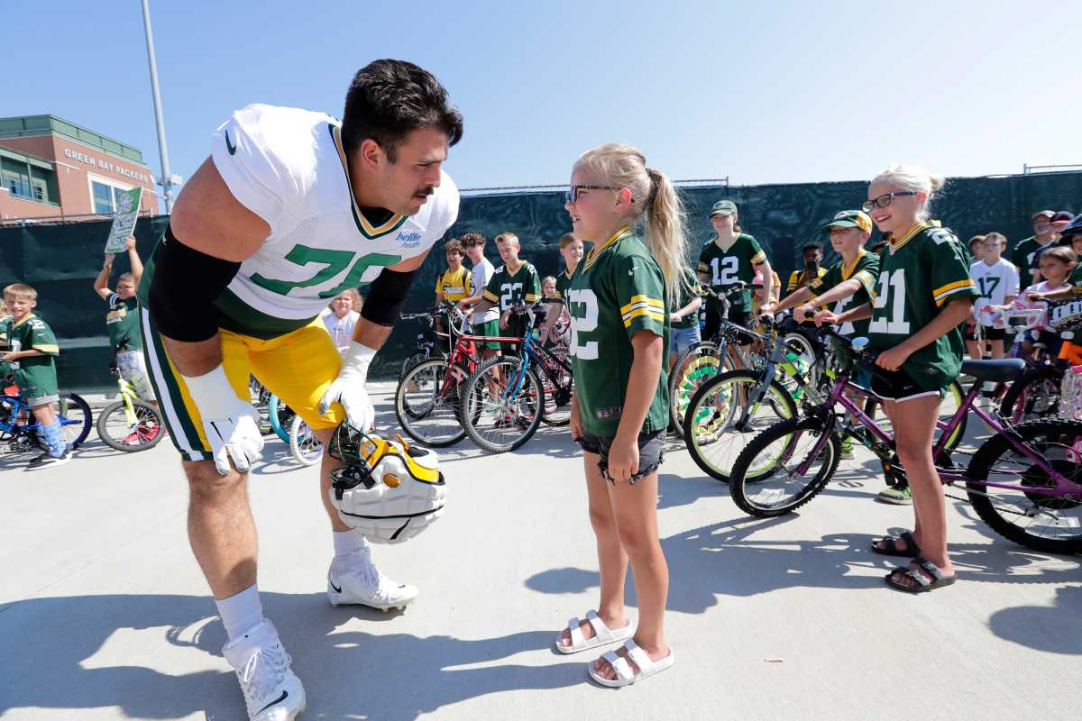 Green Bay Packers' Jack Coco rides a bike to NFL football training