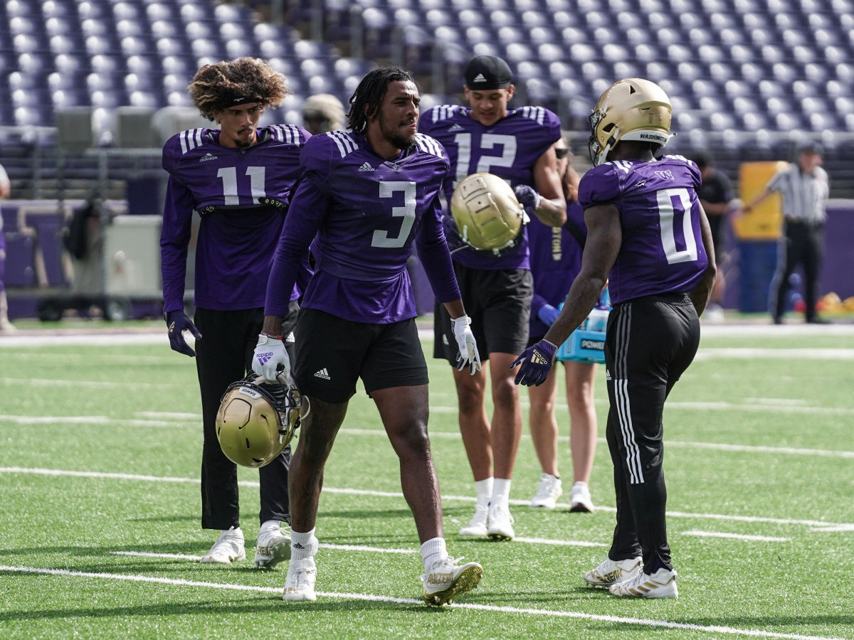 Husky wide receivers Jalen McMillan (11), Taj Davis (3), Denzel Boston (12) and Giles Jackson (0) during a lull in practice.