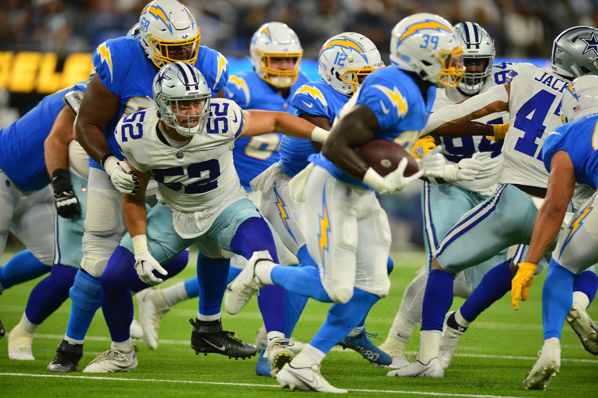 Dallas Cowboys defensive end Mika Tafua (52) is held back by Los Angeles Chargers guard Jamaree Salyer (68) during the second half at SoFi Stadium.