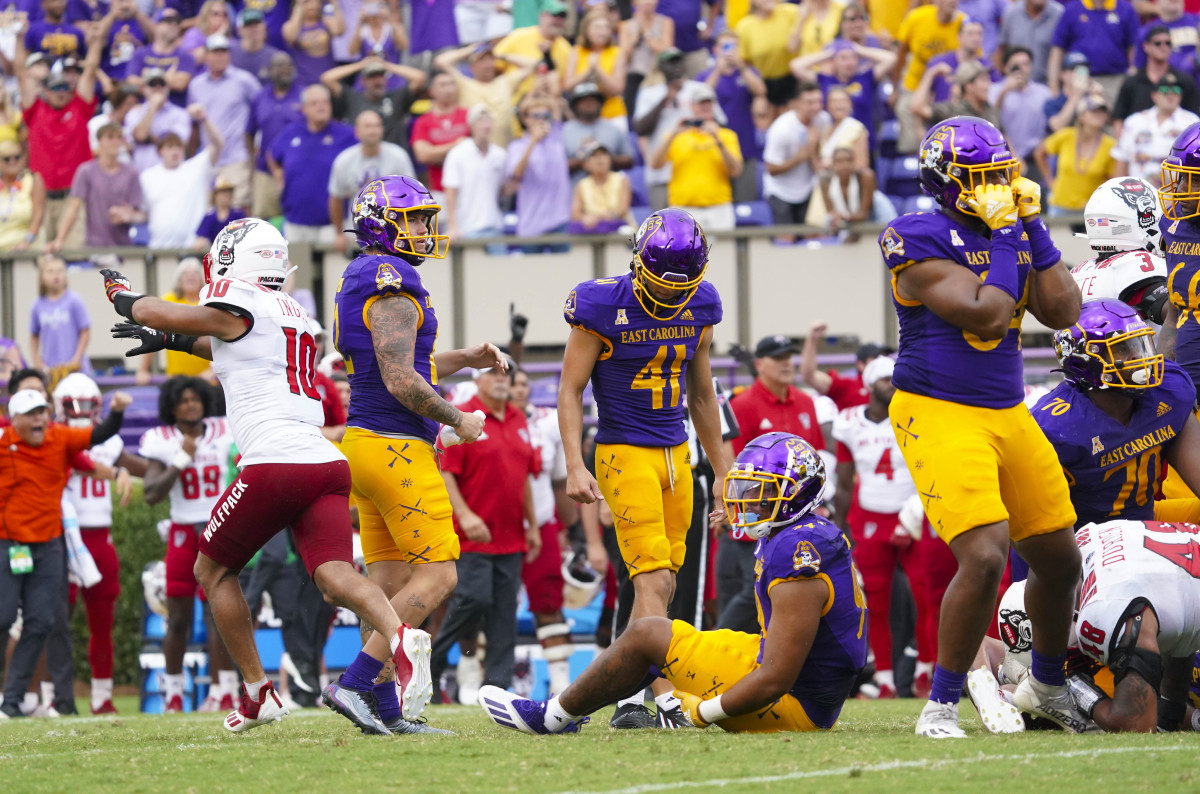 East Carolina Pirates punter Luke Larsen (12), linebacker Eric Doctor (44) and tight end D'Angelo McKinnie (84) react to place kicker Owen Daffer (41) missed field goal attempt at the end of the game against the North Carolina State Wolfpack at Dowdy-Ficklen Stadium.