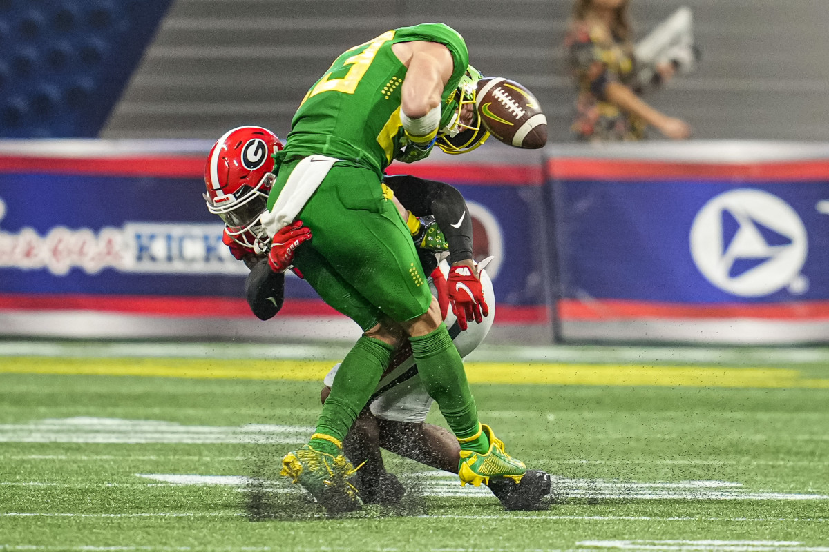 Oregon Ducks wide receiver Chase Cota (23) loses the ball after being hit by Georgia Bulldogs defensive back Christopher Smith (29) during the second half at Mercedes-Benz Stadium.