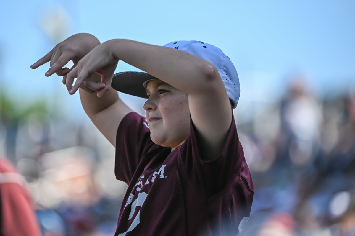 A young Texas A&M Aggies fan demonstrates the proper way to do a Horns Down against the Texas Longhorns. It's a 15-yard taunting penalty during a game in the Big 12 (but the fans can do it all they want).