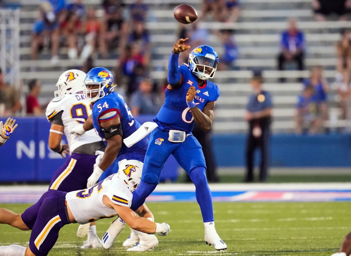 Sep 2, 2022; Lawrence, Kansas, USA; Kansas Jayhawks quarterback Jalon Daniels (6) throws a pass as he is hit by Tennessee Tech Golden Eagles defensive lineman Daniel Rickert (55) during the first half at David Booth Kansas Memorial Stadium.