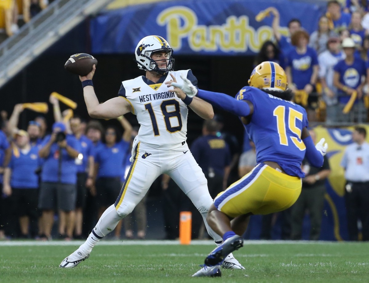 Sep 1, 2022; Pittsburgh, Pennsylvania, USA; West Virginia Mountaineers quarterback JT Daniels (18) passes against pressure from Pittsburgh Panthers defensive back Rashad Battle (15) during the first quarter at Acrisure Stadium.