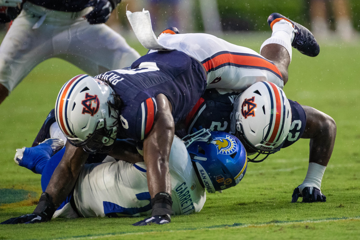 Auburn Tigers linebacker Owen Pappoe (0) and defensive end Colby Wooden (25) take down San Jose State Spartans running back Shamar Garrett (24) during the San Jose State vs Auburn game on Saturday, Sept. 10, 2022.