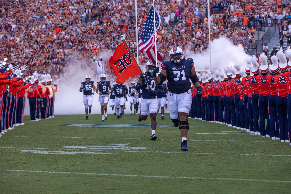 Auburn Tigers offensive lineman Brandon Council (71) carries the American flag as the Tigers take the field prior to the San Jose State vs Auburn game on Saturday, Sept. 10, 2022.